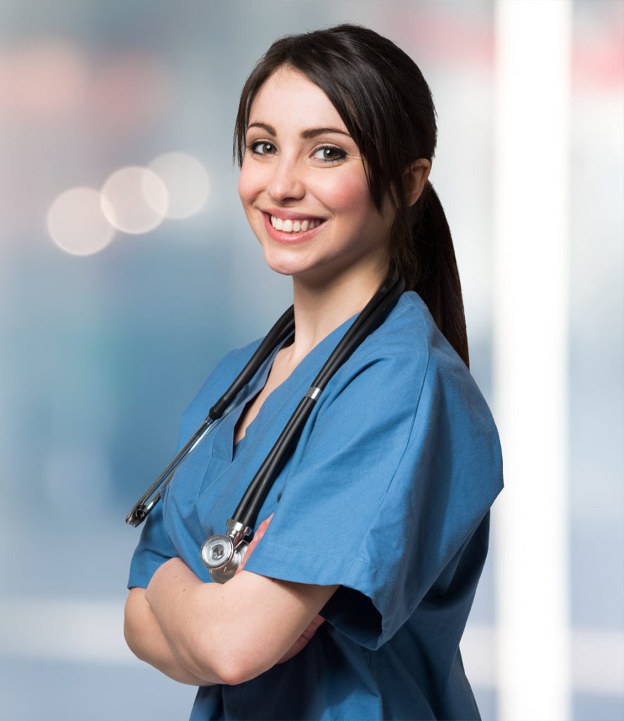 A woman in blue scrubs with her arms crossed.